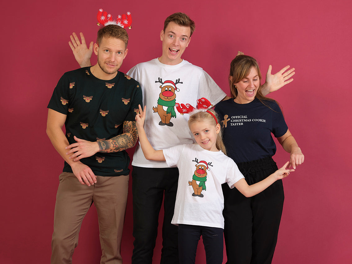 To mænd, en kvinde og et barn iført hver deres T-shirt med juletema.