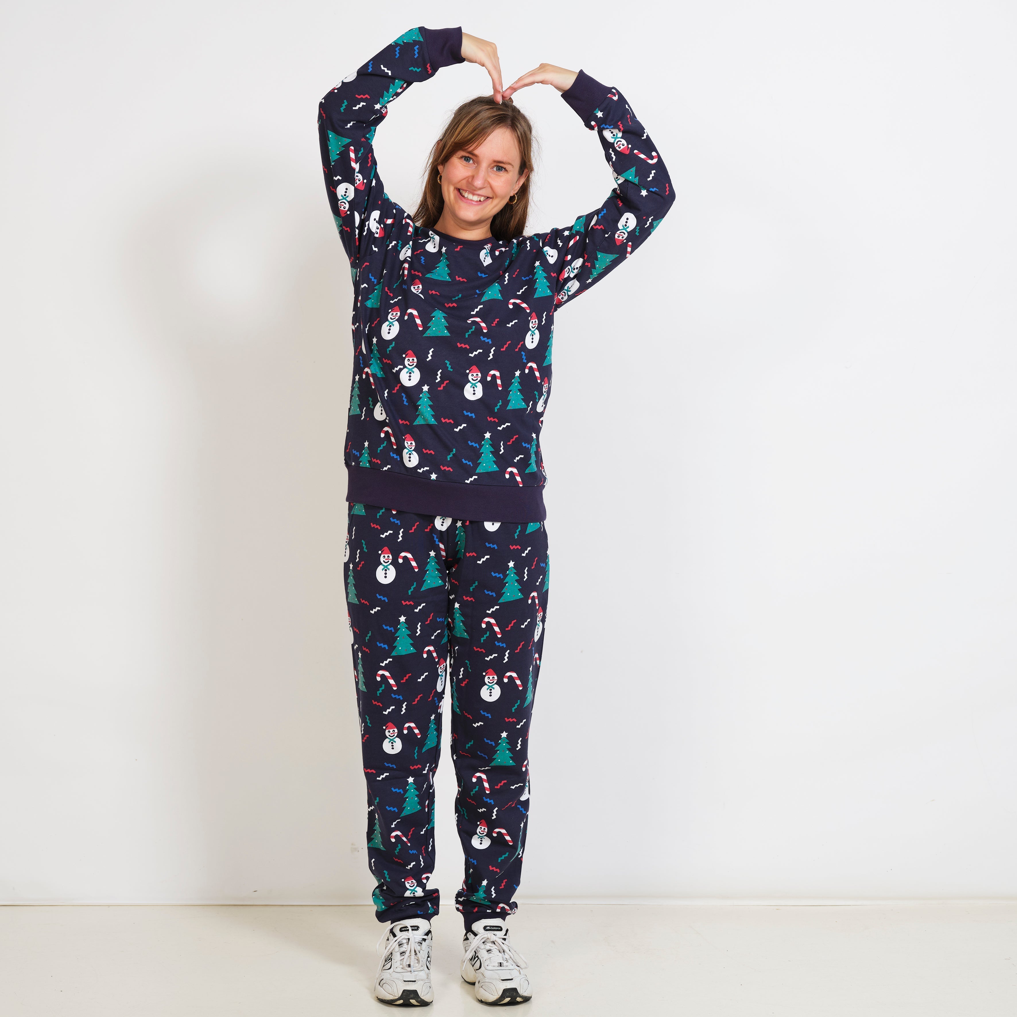 En smilende dame poserer i hendes julesweatsuit.