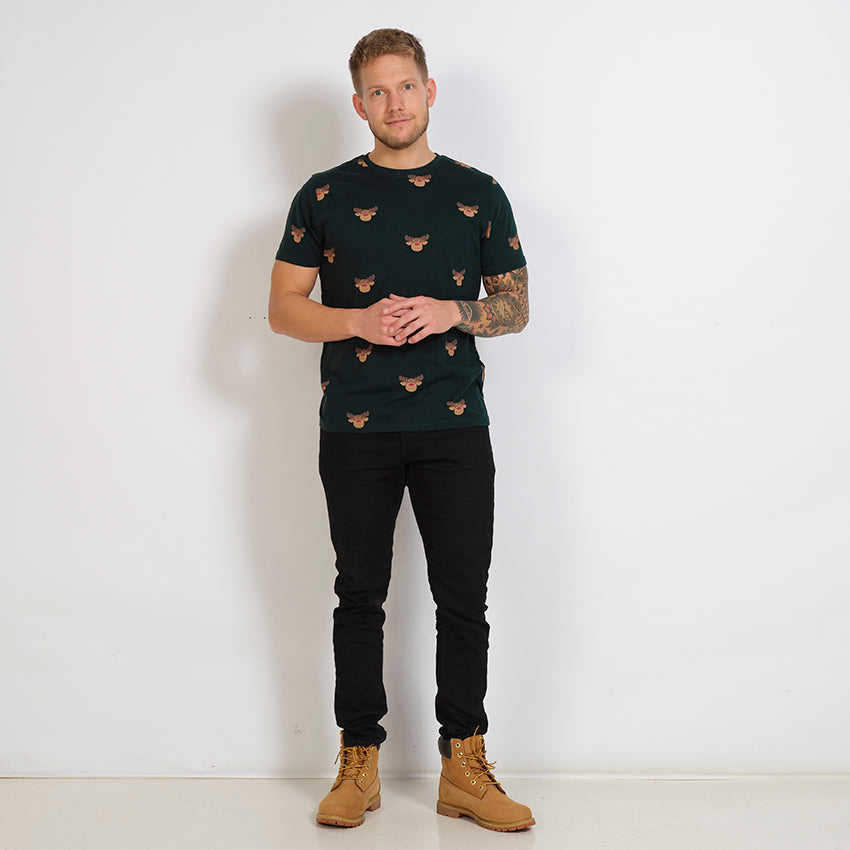 En mand poserer i en fin, sort T-shirt med rensdyr på.