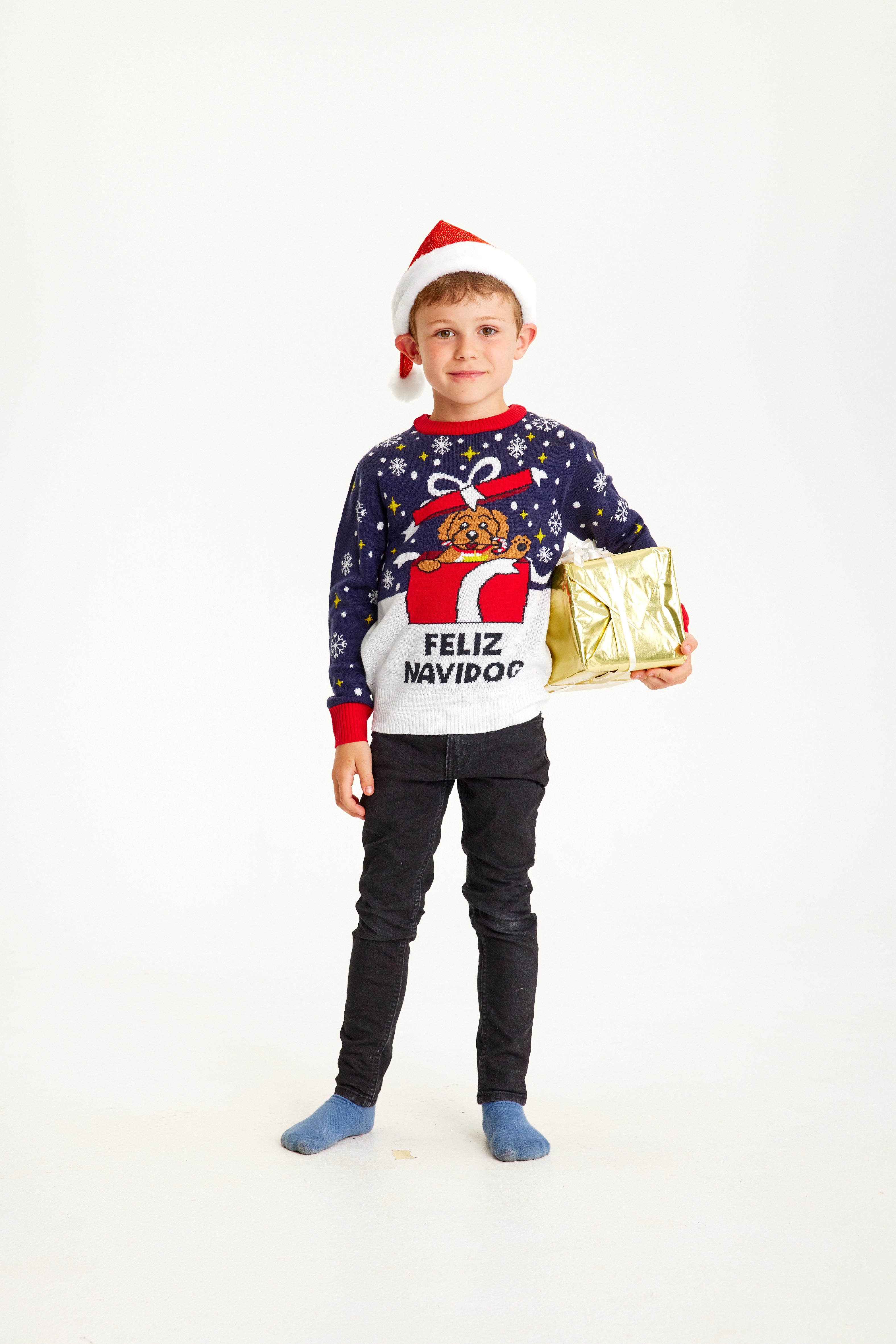 Dreng med julesweater og en pakke i hånden.