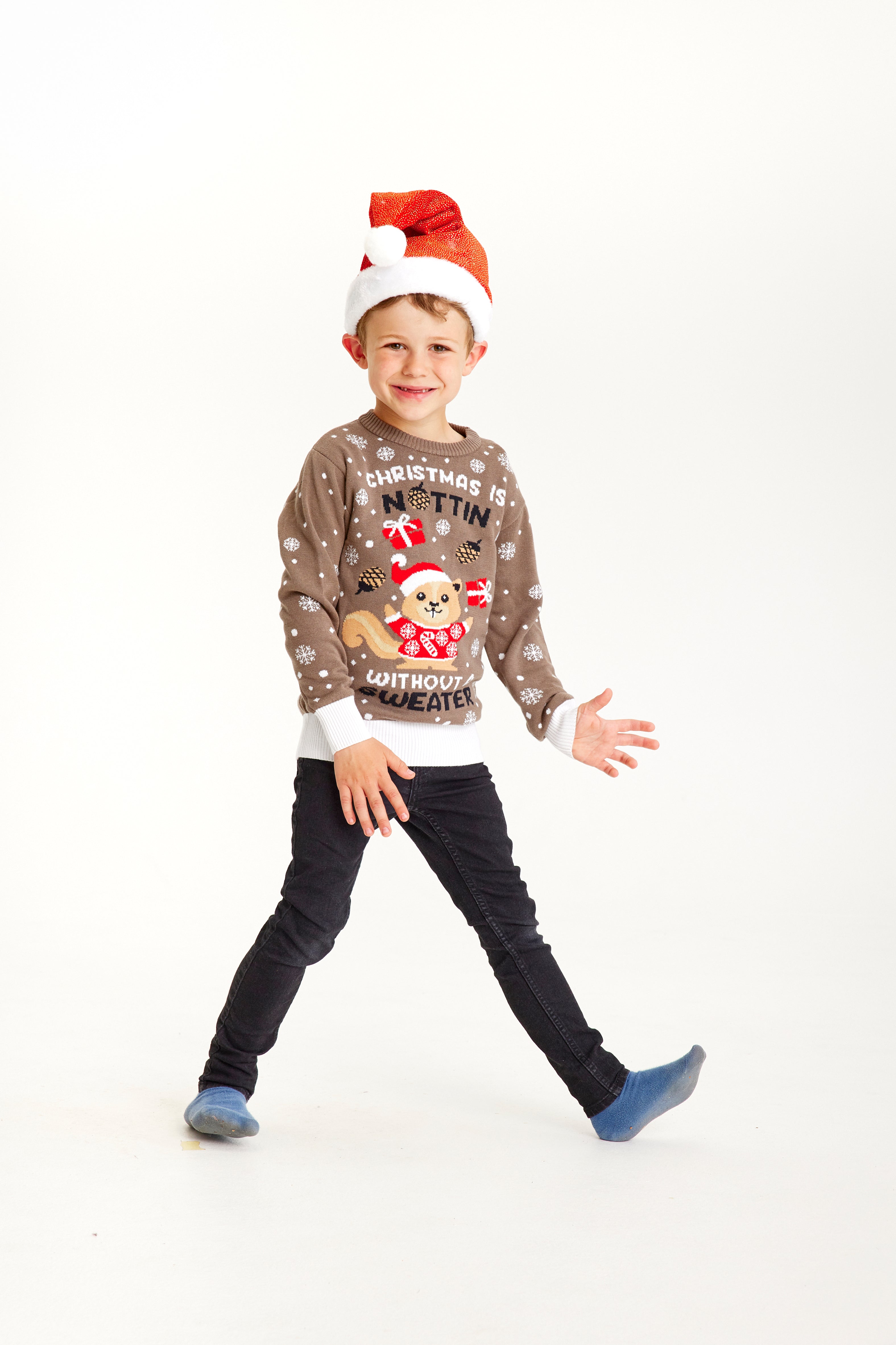 Een kind dat loopt en een bruine kersttrui draagt met de quote 