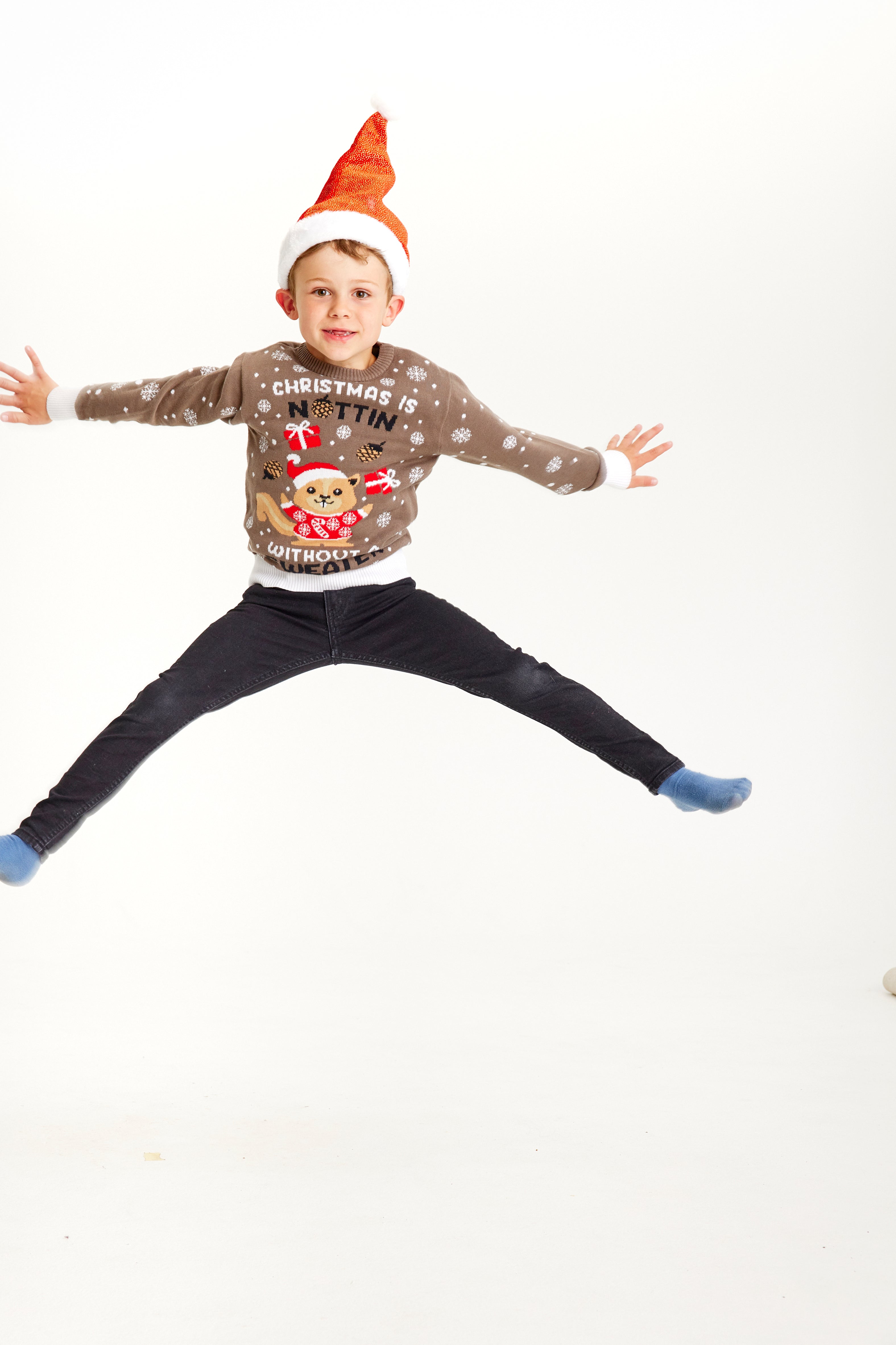 Een springend kind dat een bruine kersttrui draagt met de quote 