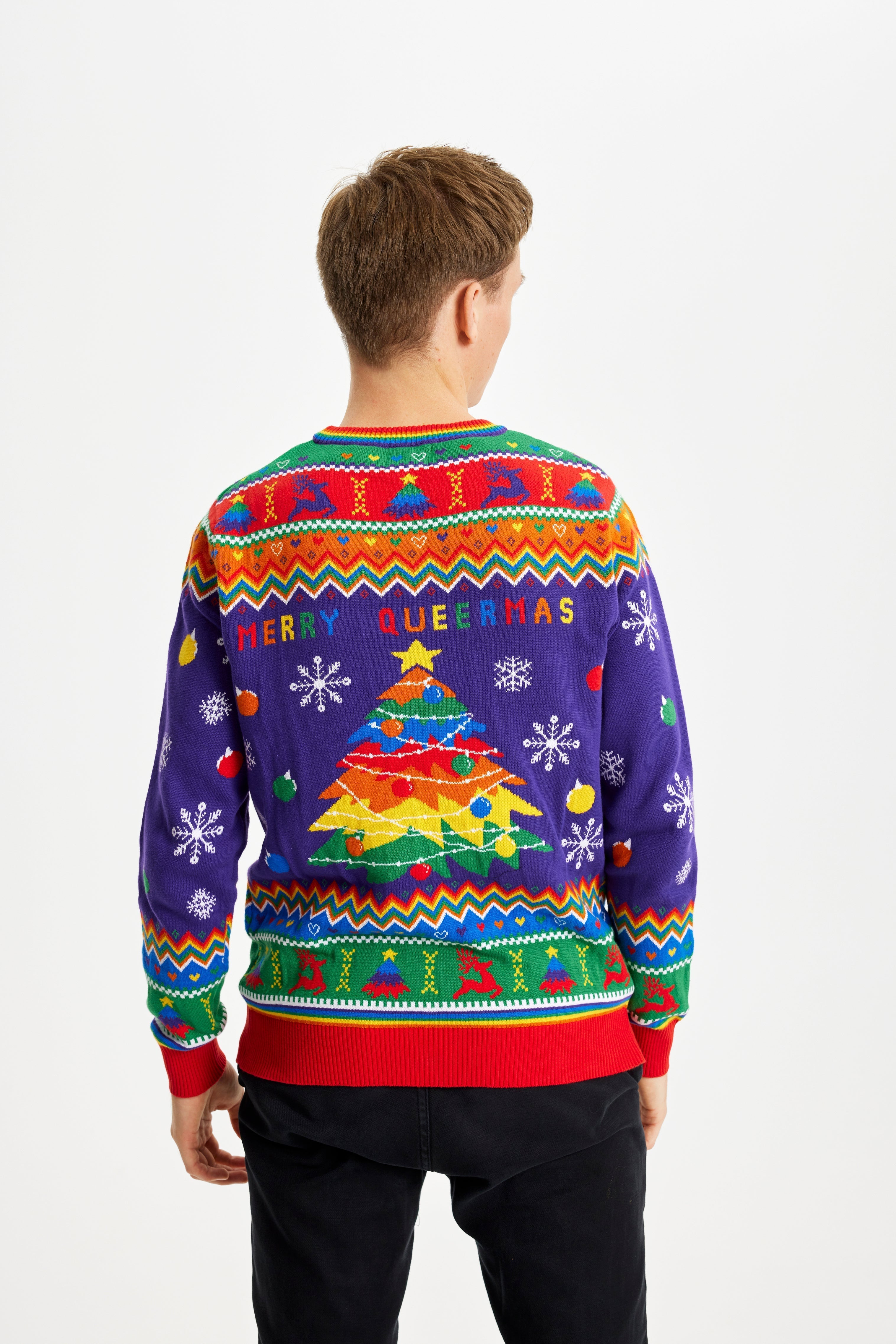 Een man met zijn rug gedraaid draagt een regenboogkleurige kersttrui met de quote 