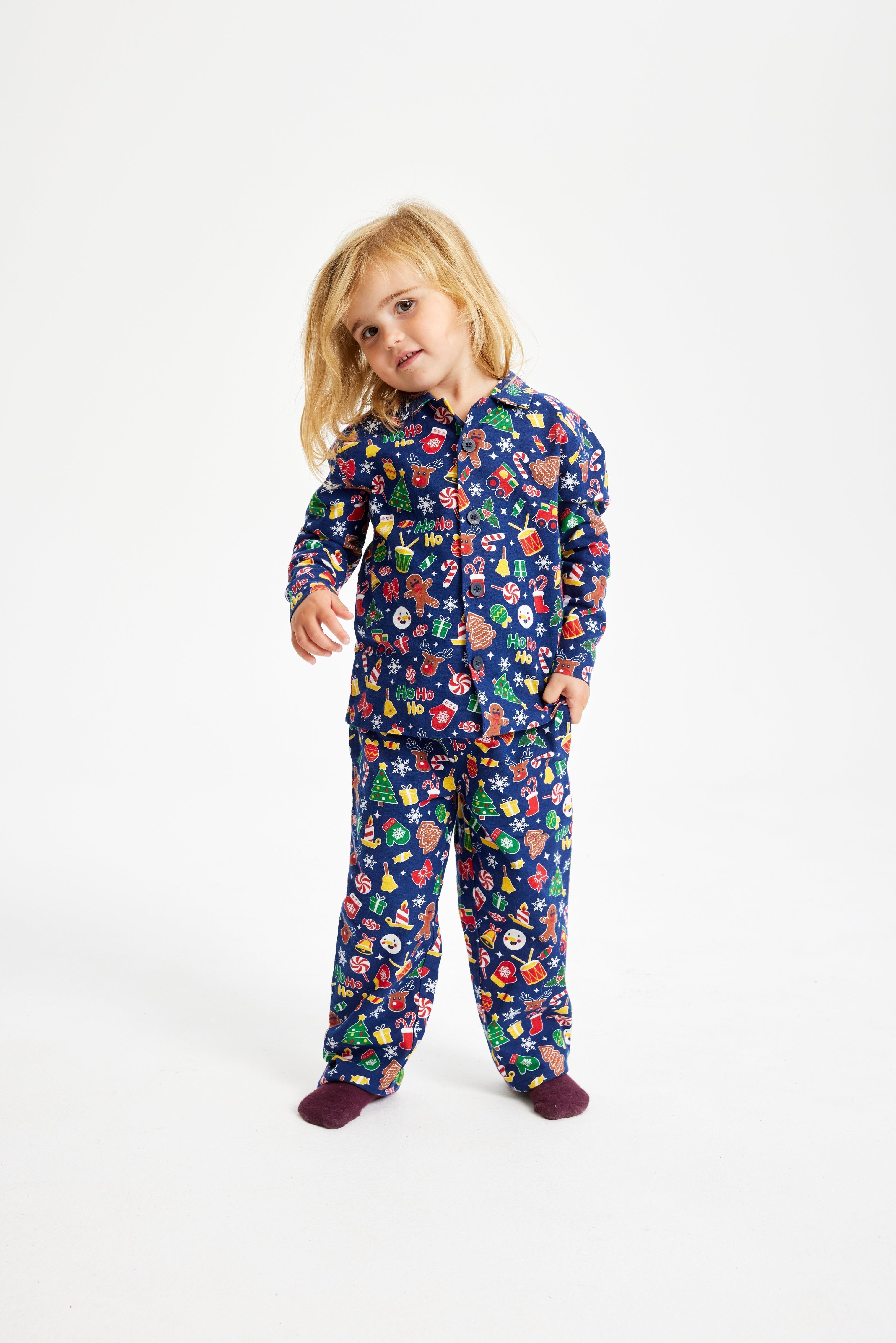 Een schattig kind in een blauwe kerstpyjama.