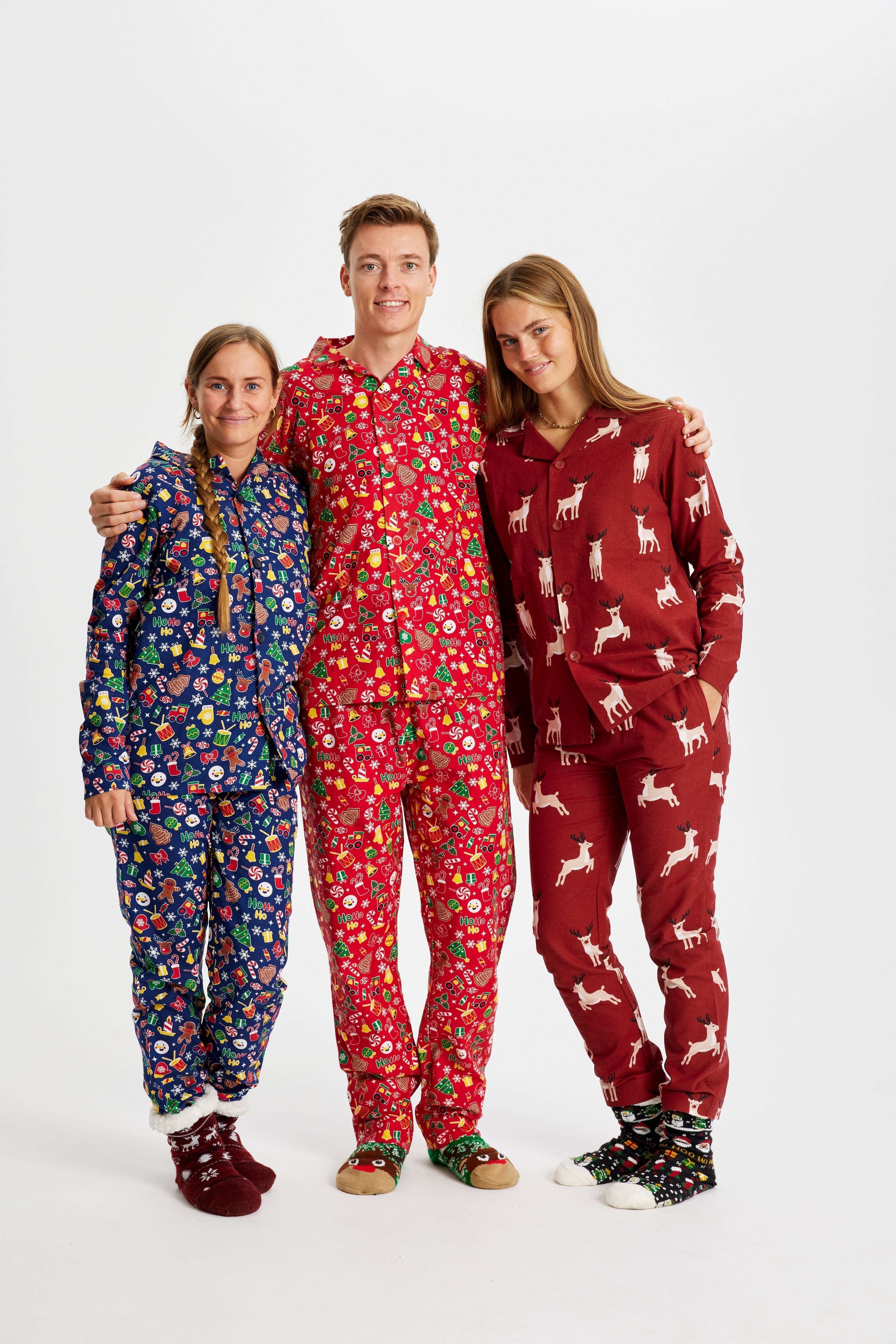 Drie mensen die elk hun eigen kerstpyjama dragen.