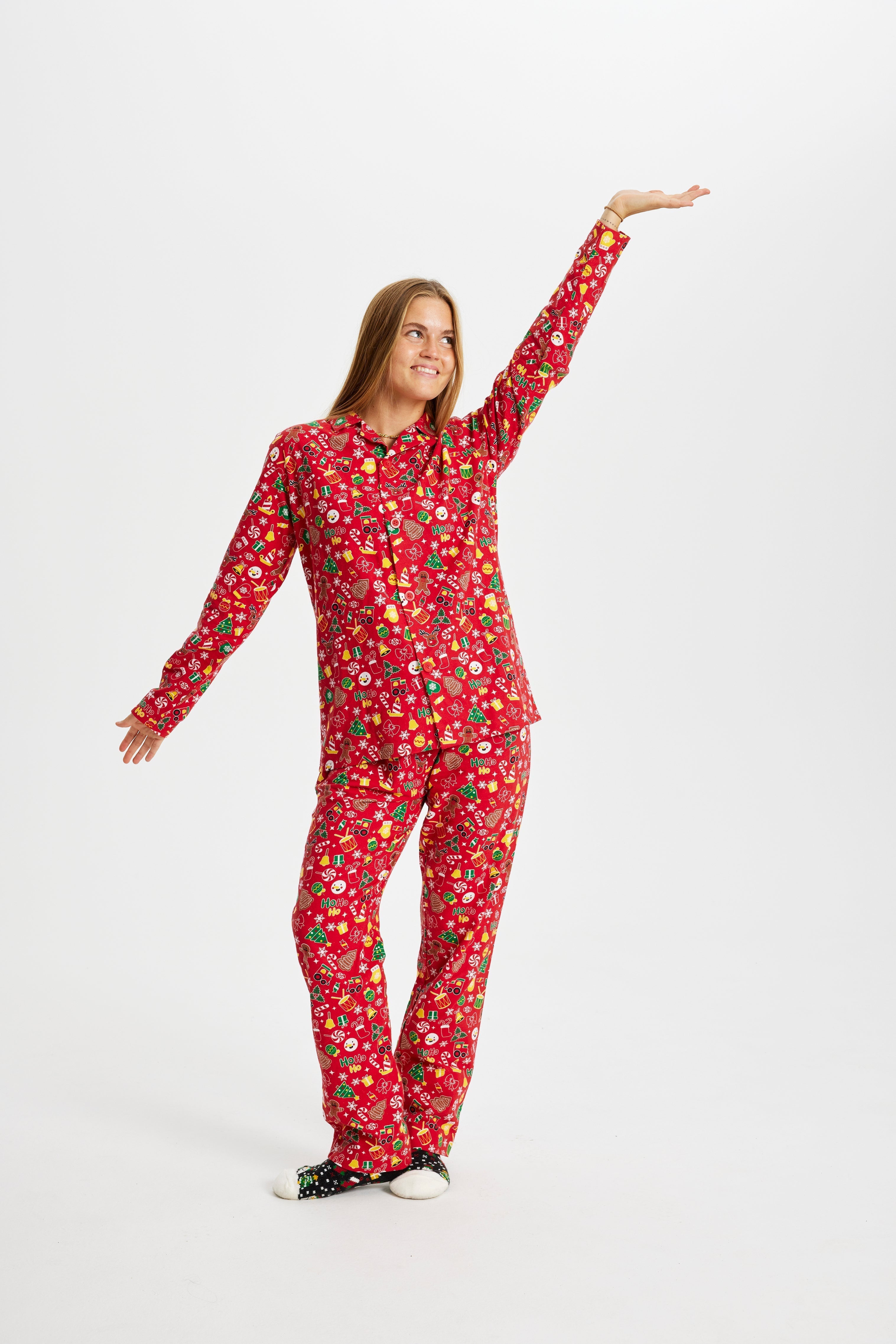 Een poserende vrouw met een rode kerstpyjama.