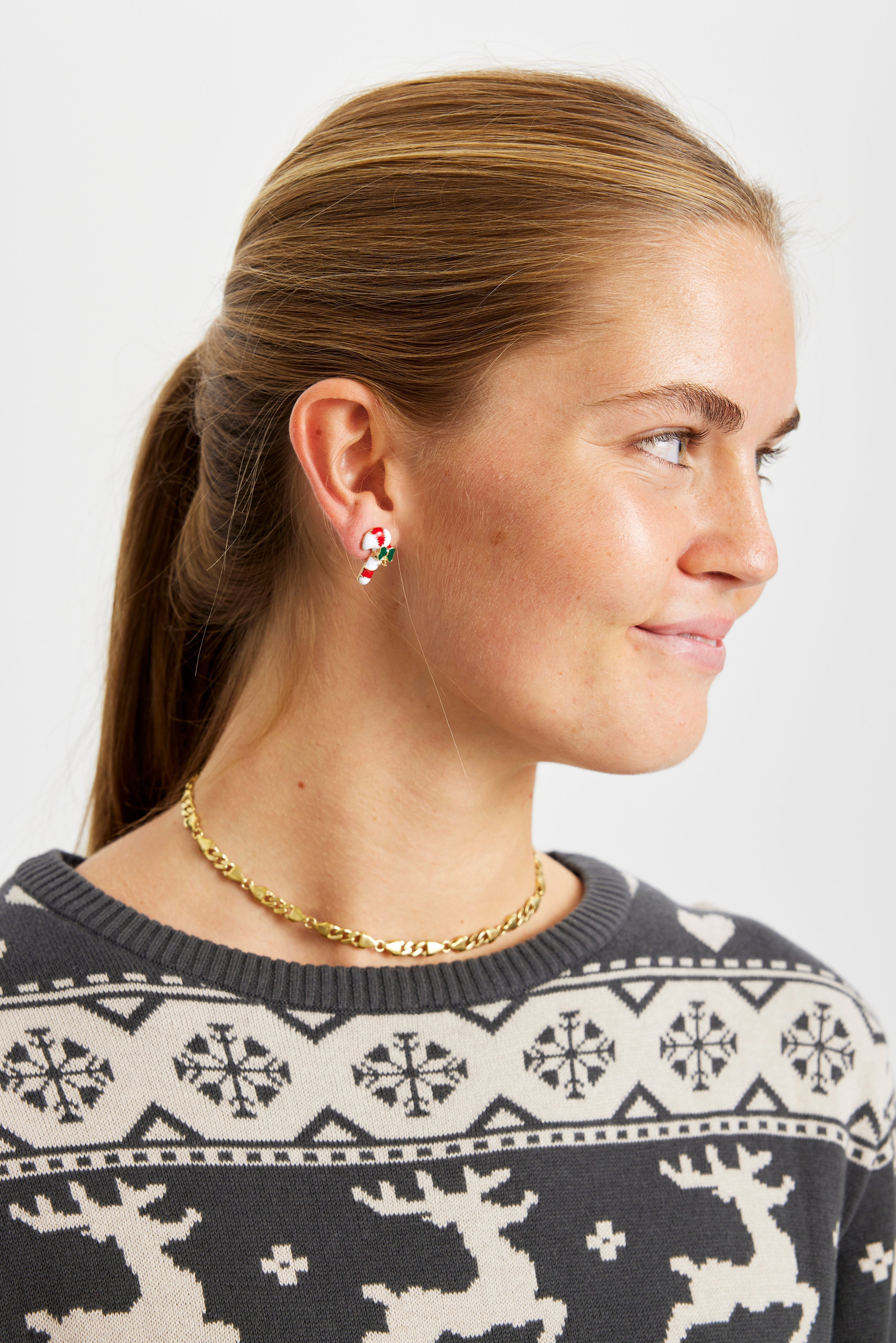 Een vrouw draagt kerstoorbellen.