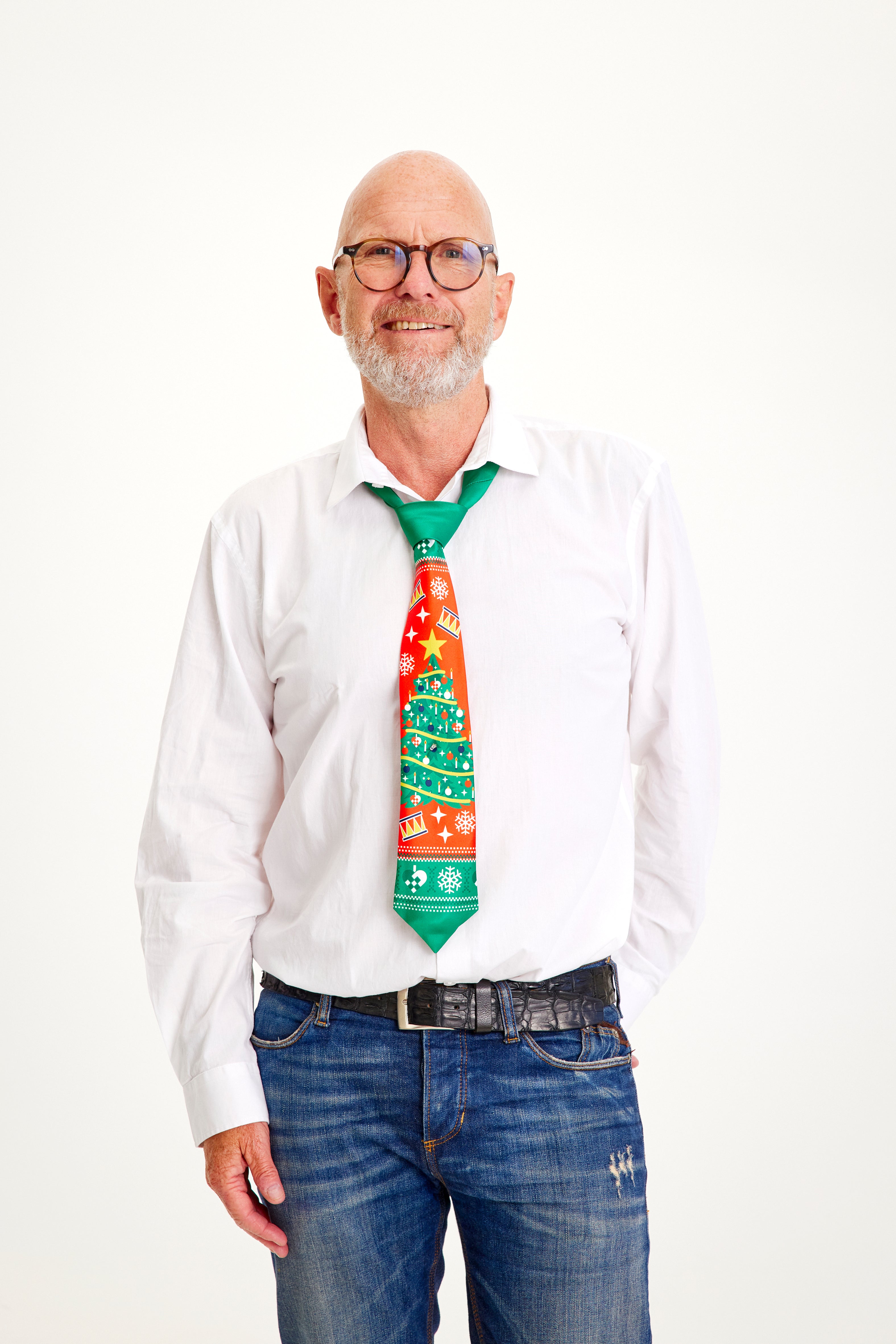 Een lachende man met een wit overhemd en een rode en groene stropdas.